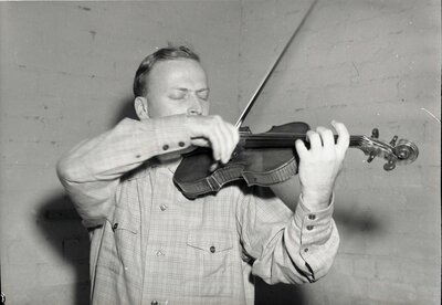 Concert violinist Yehudi Menuhin plays the violin after recovering from injury.
