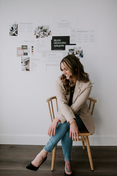 Website copywriter Erika Fitzgerald sitting in a wood chair