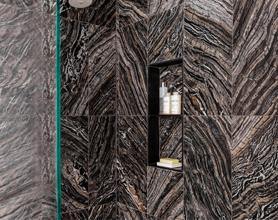Title: Bathroom Trends: South End Renovation  Description: Boston Globe Magazine features our South End primary bathroom renovation. Highlighting a walk-in shower with moody black and grey marble walls, setting a trend in bathroom design.