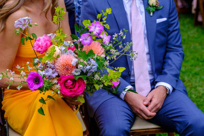 Wedding guests hold bright fresh wedding flowers.