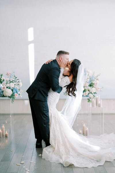 Emotional kiss during wedding ceremony with floral decor, by Toronto wedding photographer