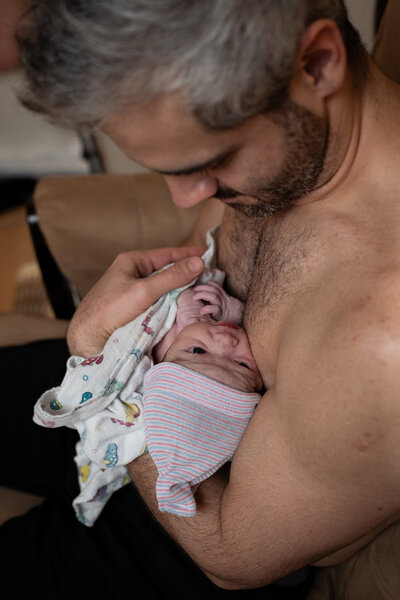 dad looking at newborn in the baby warmer at Overlake Childbirth Center in Bellevue, WA, captured by Seattle Birth Photographer, Becky Langseth.
