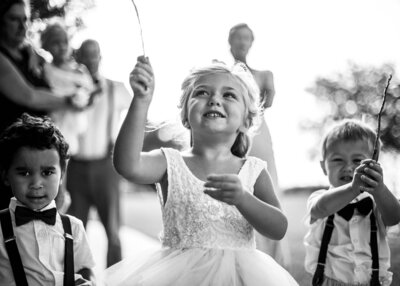 Black and white photo of flower girl and ring bearer playing at the wedding