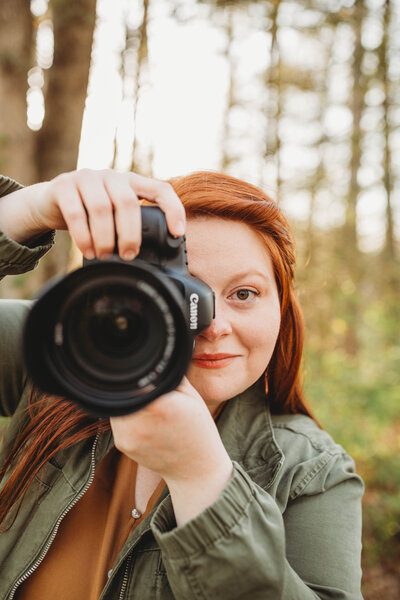 Melena, Blacksburg Virginia Photographer, holds camera and smiles.