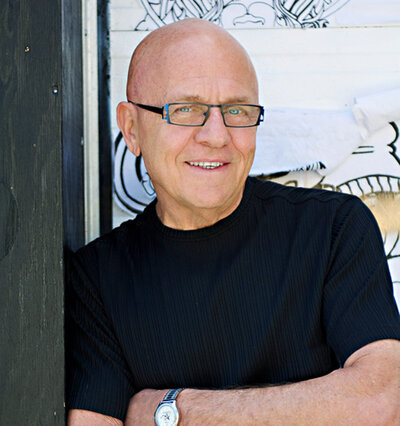 Modern headshot of a Toronto Actor against a graffiti wall wearing a black t-shirt