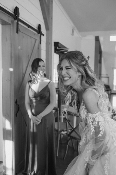 Bride and groom laugh together in front of their wedding venue