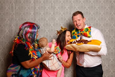 Group in photobooth pretending to take a bite of. a large sandwich prop