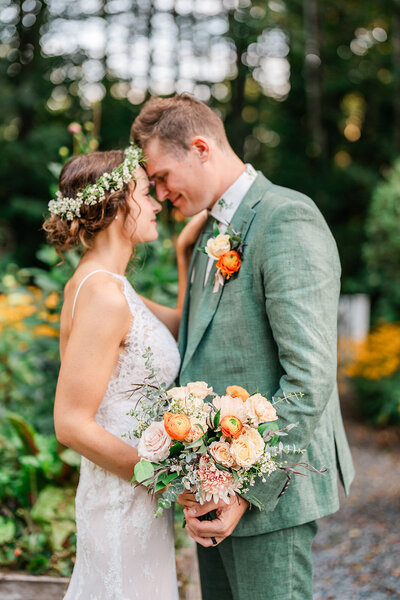 A newlywed couple leans together to share a moment after getting married during their Maine micro wedding.
