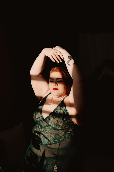 A person in lingerie with their arms over their head 