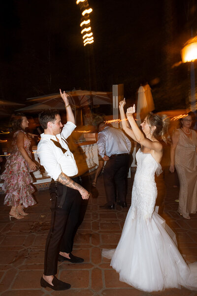 Houdini Estate wedding couple getting married in burgundy suit and white dress with bright florals 