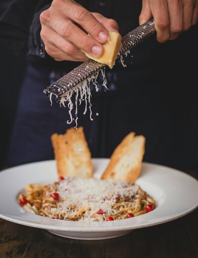 Freshly made pasta topped with a savory house-made sauce and hand-grated Parmesan cheese, a delightful twist on a classic comfort dish.