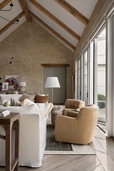 A cozy living room featuring a wooden ceiling and rustic stone walls, creating a warm and inviting atmosphere.