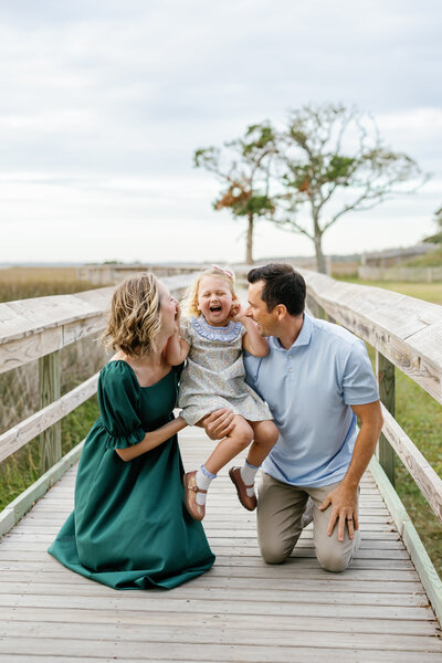 Happy family with toddler laughing by Greenfield Lake, natural Wilmington family photography