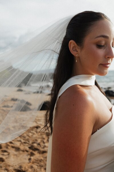 bride standing on beach in hawaii