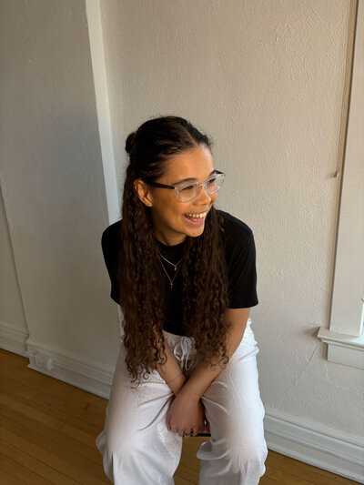 stationery artist sitting on stool smiling in natural light