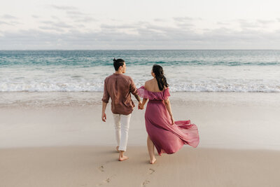 couple walking hand in hand on gorgeous beach