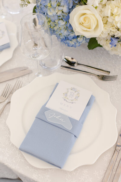White sea glass place card with calligraphy on light blue napkin for coastal wedding in Greenwich, Connecticut