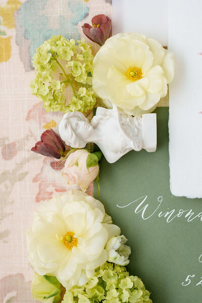 flatlay of flowers and wedding in vitation taken by Destination wedding photographer California