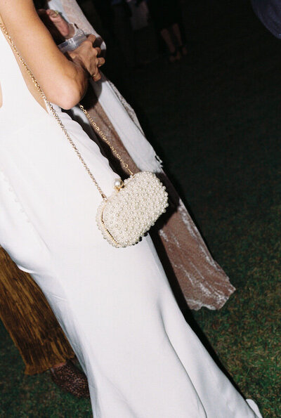 White purse is held by a bride
