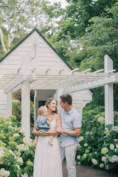 mom and dad laughing with toddler during family photos