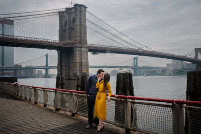 lower manhattan east river engagement couple in front of brooklyn bridge