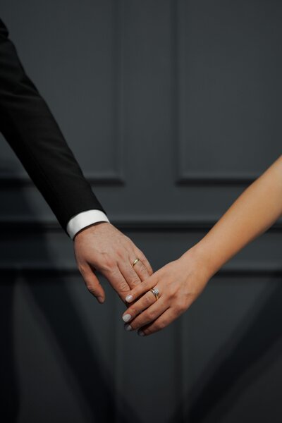 bride and groom's hands display thie wedding bands