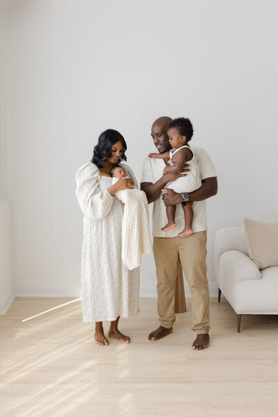 A mother and father with their two young children in their arms at The Mae Studio in Markham