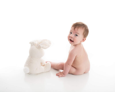 picture of baby with a stuffed bunny on white