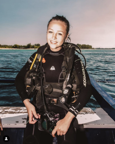Scuba Diving Girl wearing Waterproof Wetsuit and Scuba gear sitting on dive boat in Gili Trawangan Indonesia