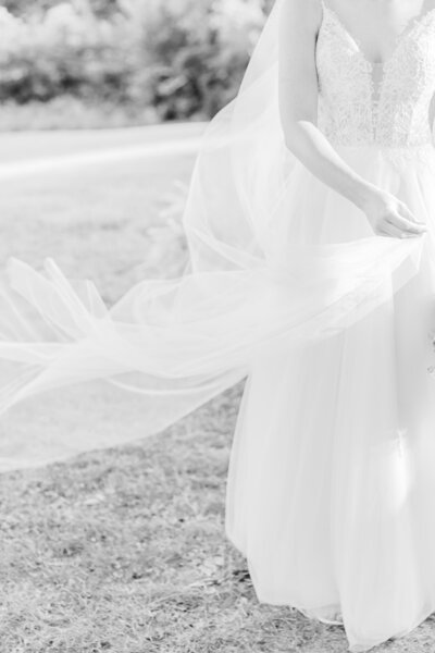 black and white Bride swishing her veil during portraits