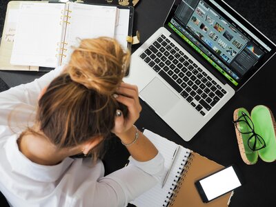 frustrated girl with head in hands at computer