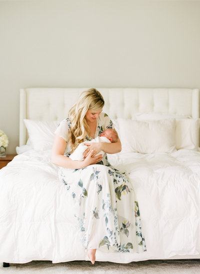 Mom smiling at her new baby while snuggling him during their newborn photography session in Raleigh NC. Photographed by newborn photographer Raleigh A.J. Dunlap Photography.