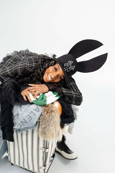 Shaniece Jones smiling and leaning over a clothing hamper