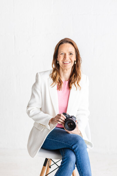 Chattanooga photographer sitting on a stool holding a camera