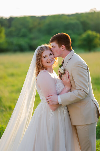 bride and groom kissing at sunset at the barn at woods fort venue