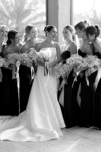 A couple sitting on Steps beach on Nantucket with the man pulling his fiancee in for a kiss