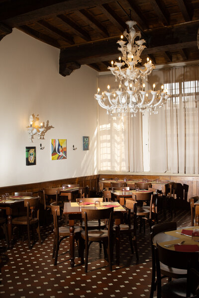 Italian restaurant  glass chandelier, and dining room tables. 