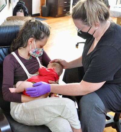 Katie with an infant and mother during a craniosacral therapy session.
