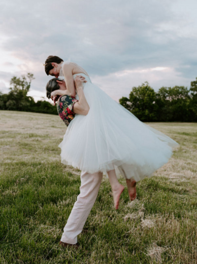 bride and groom twirling in a field near Raleigh NC