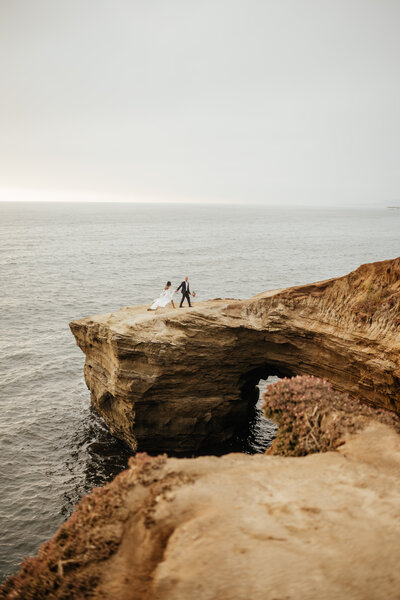 Bride and Groom standing cliffside in San Diego California
