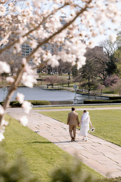 Couple walking framed by cherry blossoms at Wade Lagoon in Cleveland.