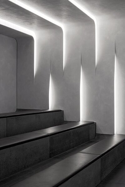 A black and white photograph of a softly lit modern staircase