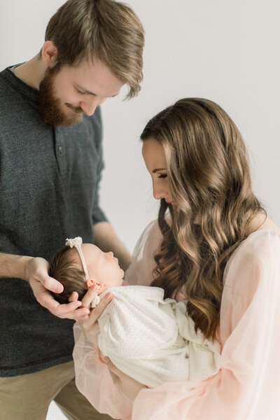 Mom and dad holding newborn baby in studio setting Milwaukee, WI