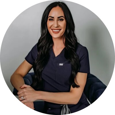 Brunette woman in scrubs smiling - Sarah Berg, DNP, FNC-P