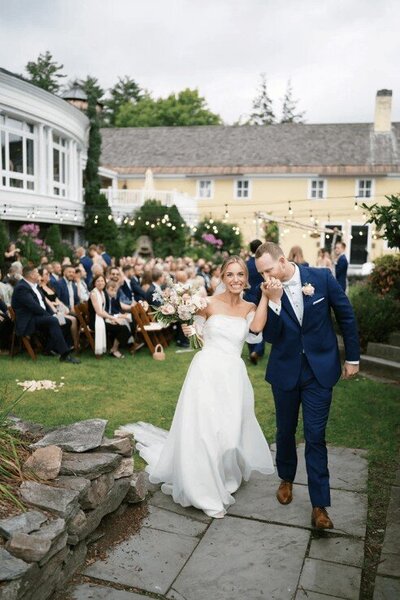 Bedford Village Inn - Wedding Couple Walking with Entourage Behind Them