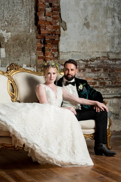 a married couple sits on a white couch
