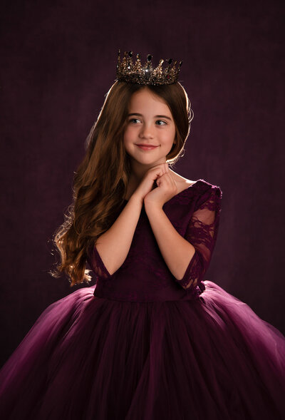 girl-in-purple-dress-against-purple-backdrop-backlit-looking-off-in-arlington-tx-studio