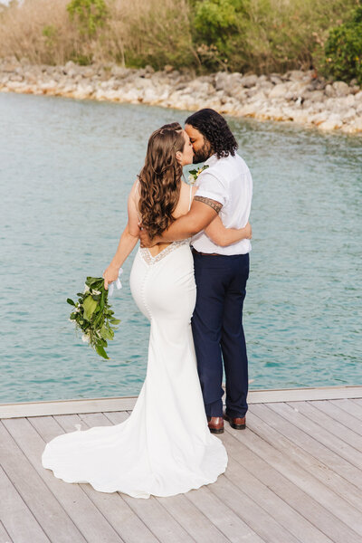 bridal couple kissing on a dock