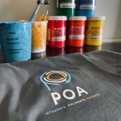 High-quality screen printing ink in green, blue, red, orange, and yellow with grey t-shirt freshly printed.