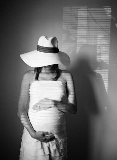 Black and white of a pregnant woman holding her belly during her maternity session